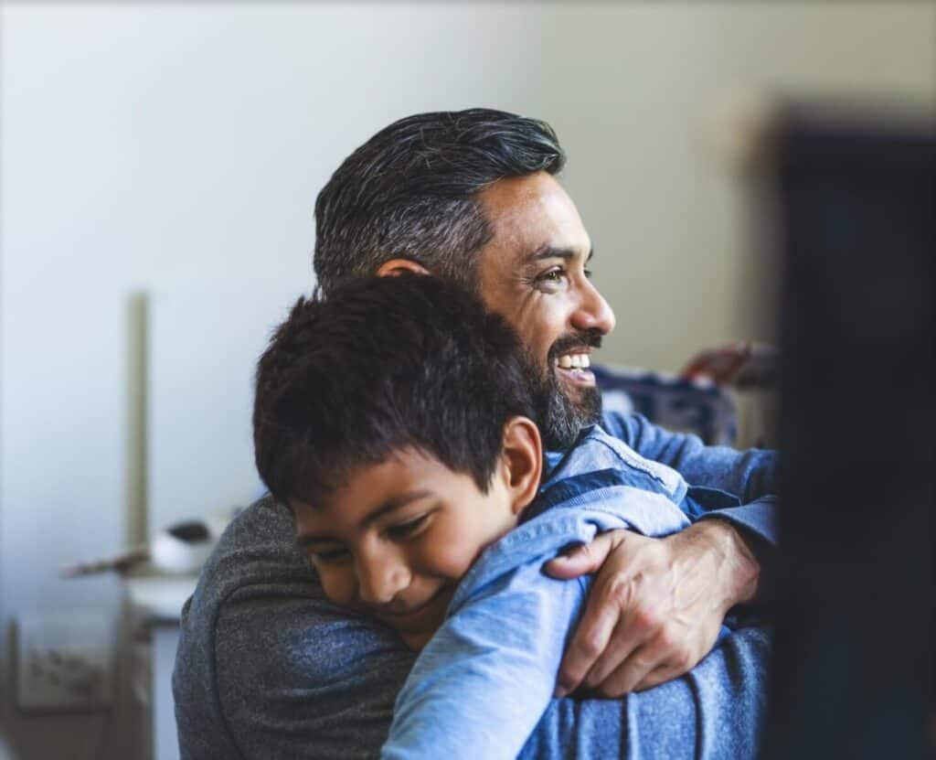 A child hugs his father