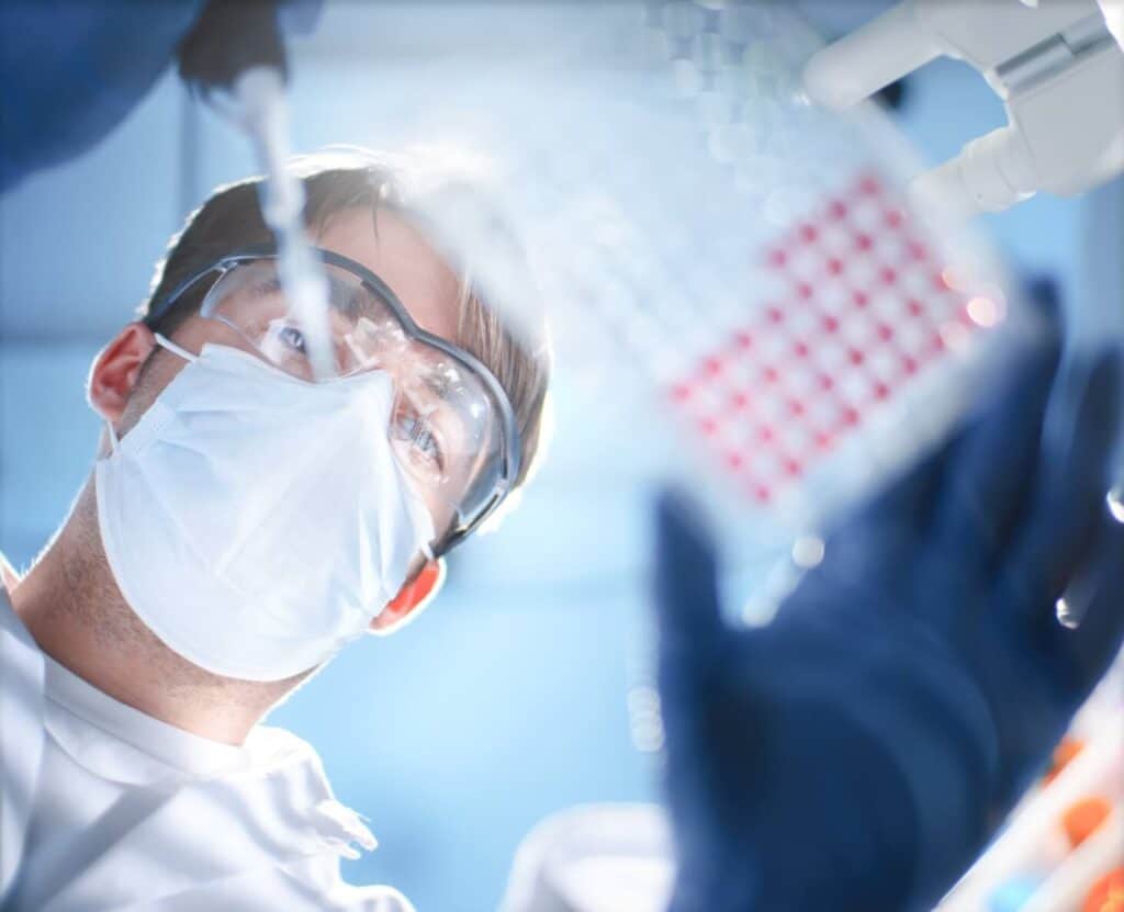 Image looking upward at a scientist using a dropper